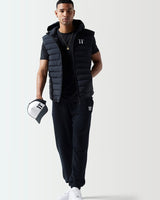 Black crew-neck T-shirt with '11' logo, partially visible under a puffer vest.