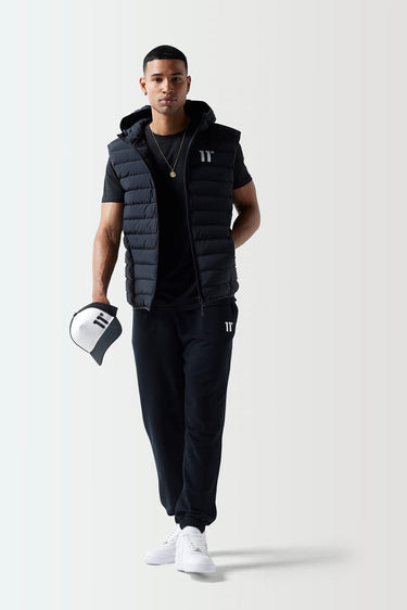Black crew-neck T-shirt with '11' logo, partially visible under a puffer vest.