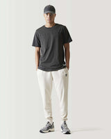 Stone beige slim-fit joggers with tapered legs and small side logo