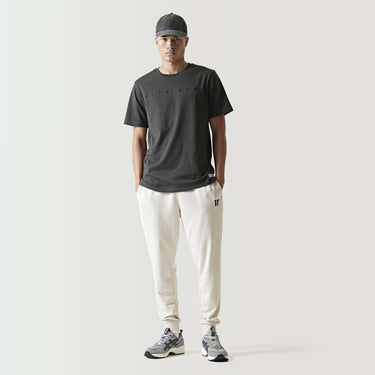 Stone beige slim-fit joggers with tapered legs and small side logo