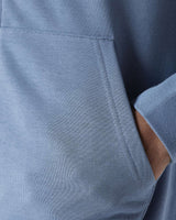 Light blue hoodie fabric close-up with stitched seam and pocket opening