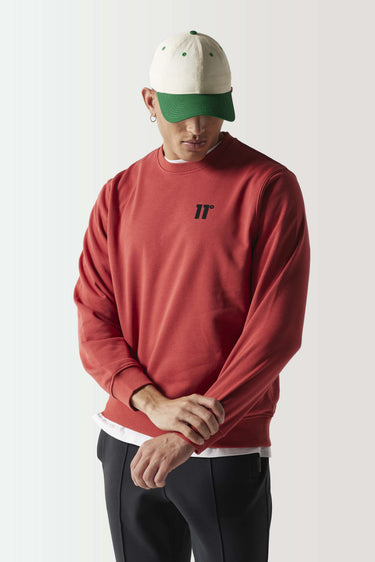 Red crewneck sweatshirt with ribbed hem and cuffs, small black chest logo