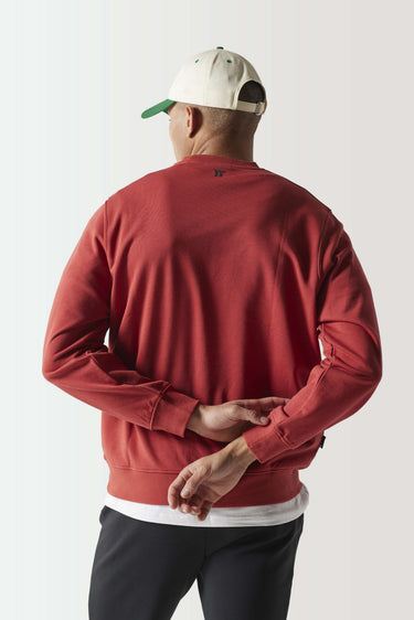 Red crewneck sweatshirt, back view with small black logo near neck, ribbed hem