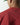 Red crewneck sweatshirt close-up showing small black logo on chest