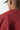 Red crewneck sweatshirt close-up showing small black logo on chest
