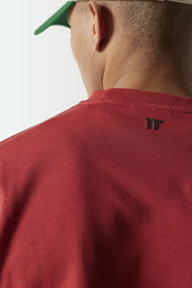 Red crewneck sweatshirt close-up showing small black logo on chest