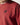 Red crewneck sweatshirt close-up with black chest logo and ribbed collar