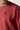 Red crewneck sweatshirt close-up with black chest logo and ribbed collar