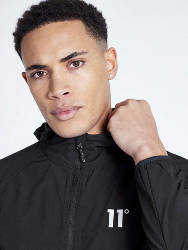 Men's black tech jacket with full zip, hood, and small '11°' chest logo