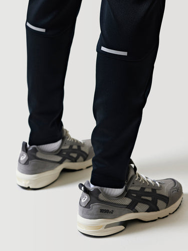Black athletic pants with white side trim and tapered ankle cuffs.