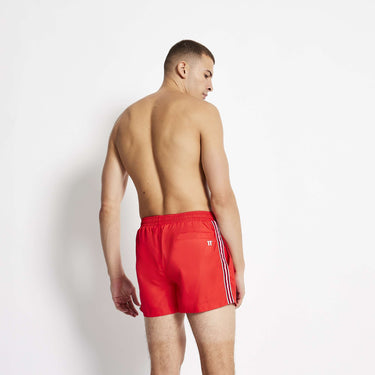 Men's red swim shorts viewed from back with white stripe tape
