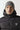 Black micro puffer jacket with hood collar, zip front, and 11° chest logo
