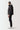 Black panel puffer jacket shown from side with full-zip front and quilted insulation