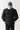 Black panel puffer jacket back view with standing collar and quilted horizontal baffles