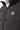 Black puffer jacket close-up: full-zip front, standing collar, and “11°” chest logo