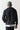 Black overhead hybrid jacket back view with hood, quilted yoke, full front zipper