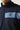 Navy full-zip sweat top close-up of light blue chest stripe with logo