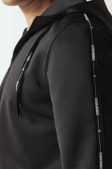 Black hoodie sleeve close-up with vertical graphic tape detail