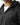 Black full-zip hoodie close-up at collar and chest with visible zipper