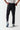 Black track pants held at waist, front crease and cuffed hems