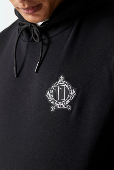 Black hoodie close-up of drawstring hood and front crest emblem