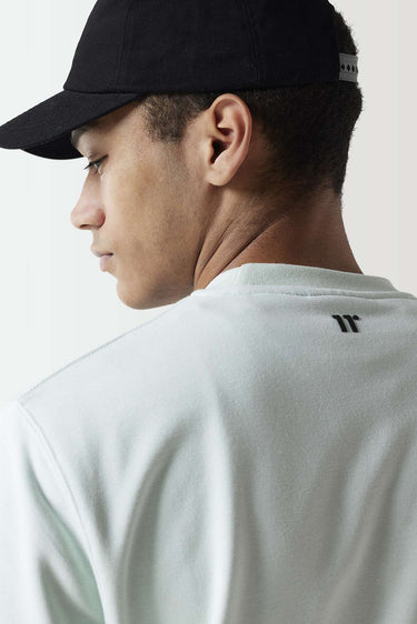 Glacier green sweatshirt close-up at back neck with black 11° logo, crew collar