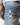 Mid-blue denim jeans with stitched distressed rip on back leg