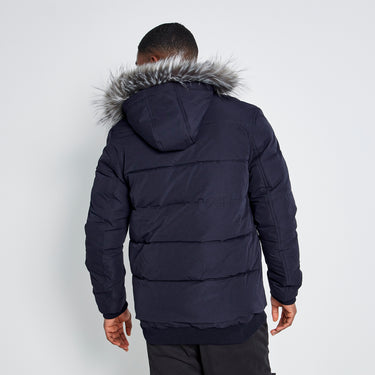 Men's dark puffer jacket back view with faux-fur hood and quilted panels