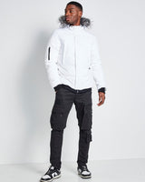 White insulated jacket with fur-trimmed hood, front zipper, and sleeve logo patch