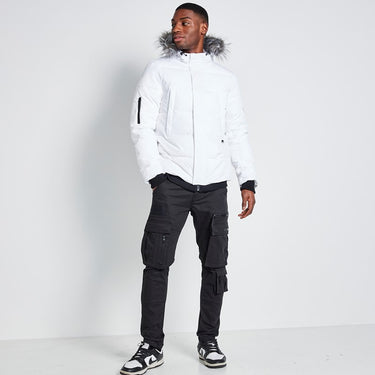 White insulated jacket with fur-trimmed hood, front zipper, and sleeve logo patch