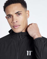 Men's black tech jacket with full zip, hood, and small '11°' chest logo