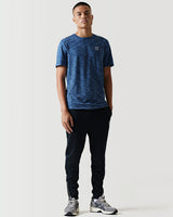 Black athletic pants with white logo on thigh and tapered legs.