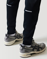 Black athletic pants with white side trim and tapered ankle cuffs.