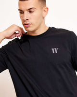 Black crew-neck t-shirt close-up of 3D embroidered '11°' logo