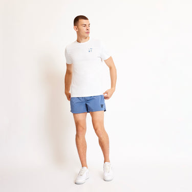Blue swim shorts with elastic waistband and side taping; visible small logo detail.