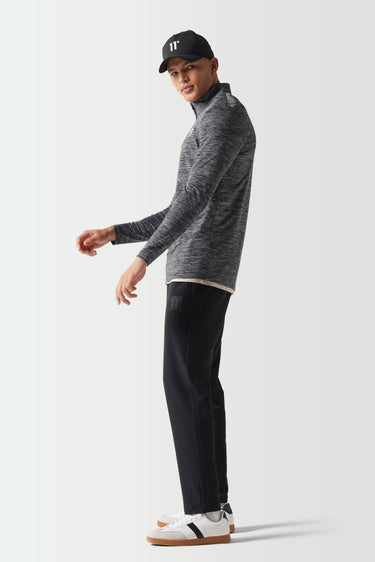 Space-dye long-sleeve quarter-zip top in dark heather with black trim and neck zipper.