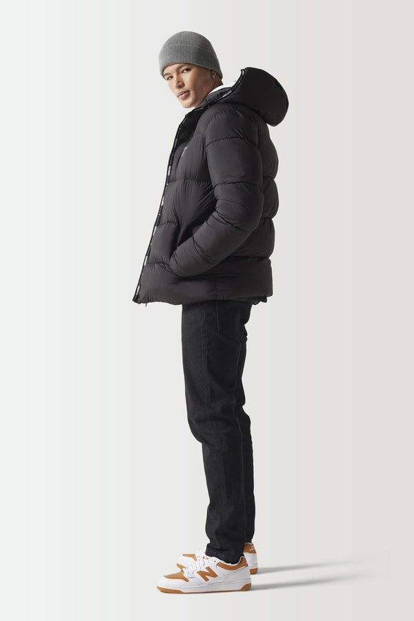 Black micro puffer jacket, side profile with hood and zip front
