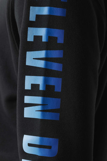 Black hoodie close-up of tall blue gradient logo-style print.