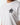 White crew-neck T-shirt with small crest emblem near chest