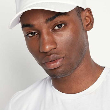 Close-up of white baseball cap with black “11°” logo on top front